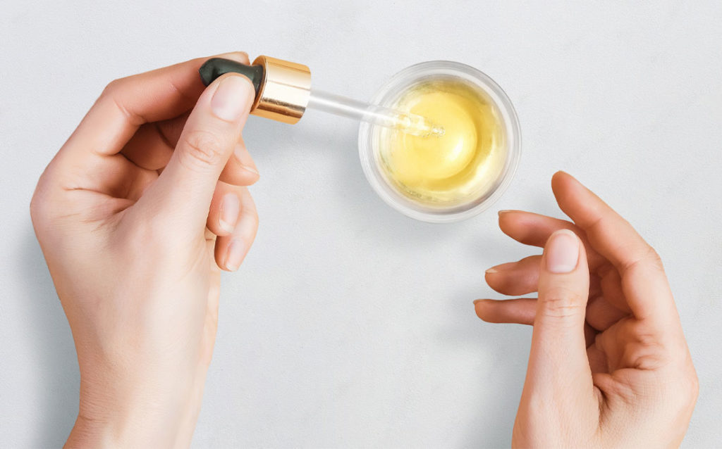 Photo showing eye dropper used to apply sun-damage serum to the skin.