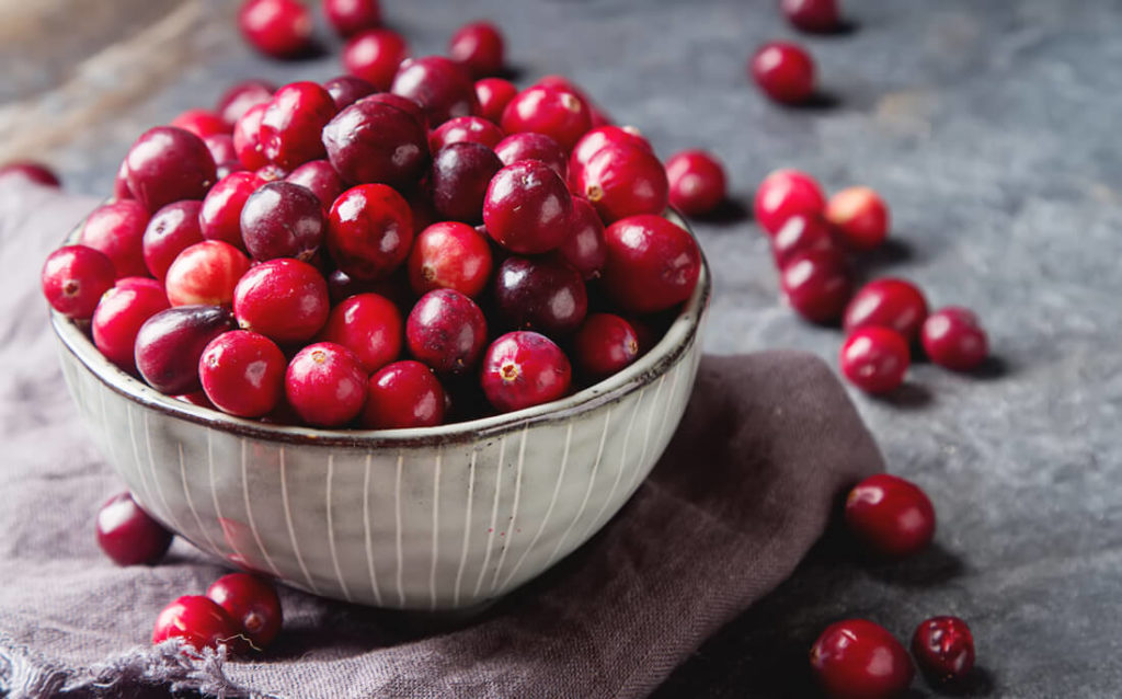 A bowl of cranberries, full of benefits for your skin.