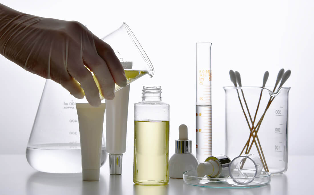 Photo showing test tubes and beakers of chemicals commonly found in skincare products