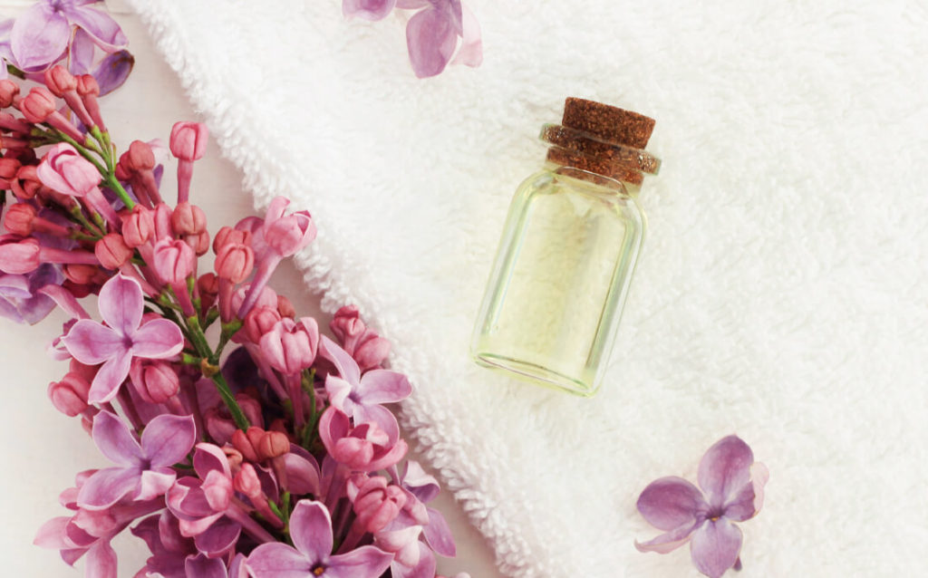 Photo showing bottle of clarifying facial toner and some natural flower blossoms